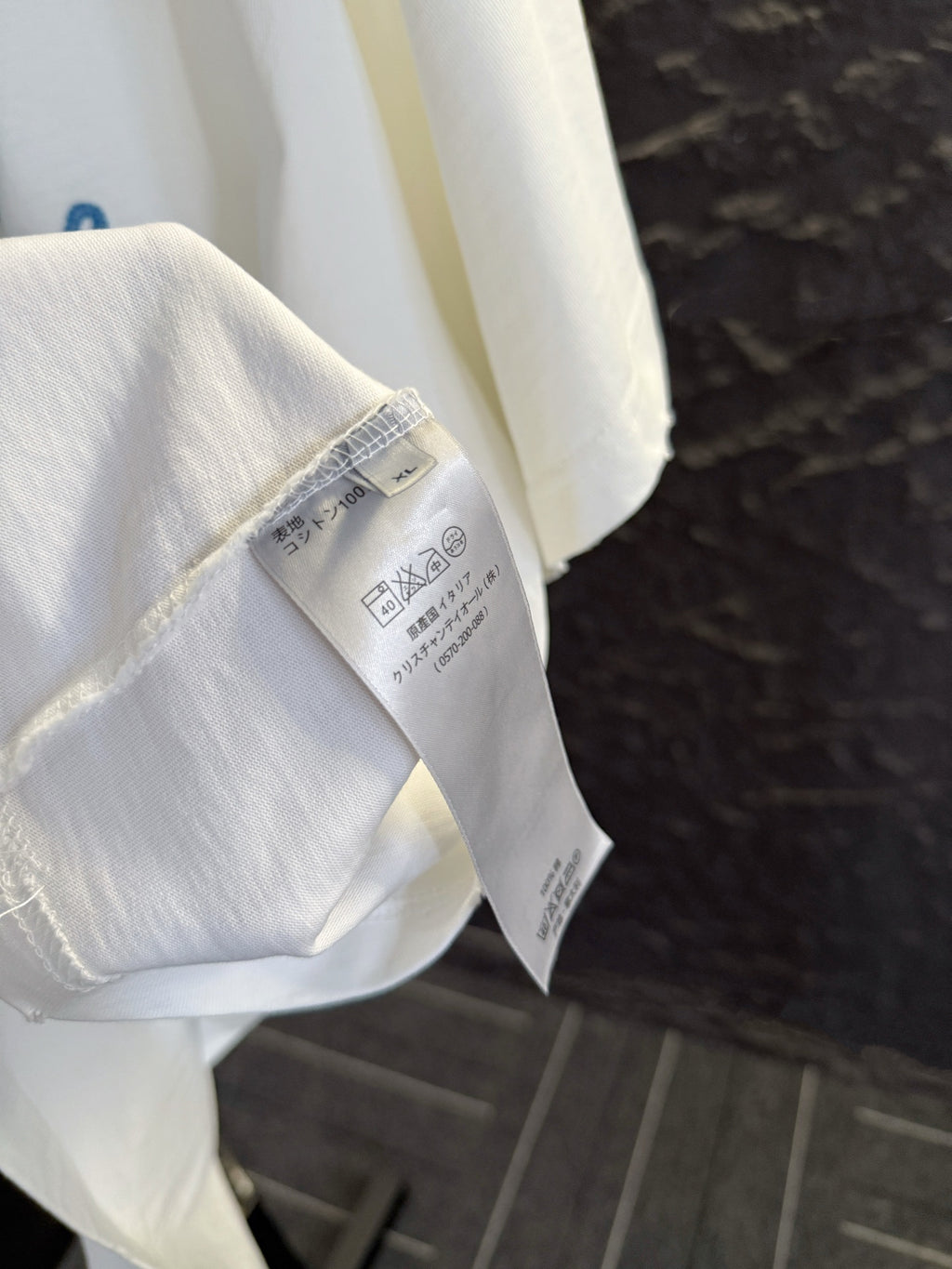 White short-sleeve T-shirt showing inner care label on sleeve seam