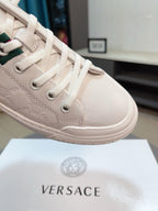 Versace white high-top sneakers close-up of textured upper and lace eyelets