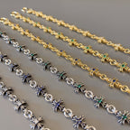 Close-up star charm bracelets in gold, silver, and blue-green stone accents
