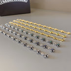 Long charm bracelets with silver and gold chain links and blue or green stones