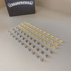 Charm bracelet set in silver, gold, and blue-green with star link pendants