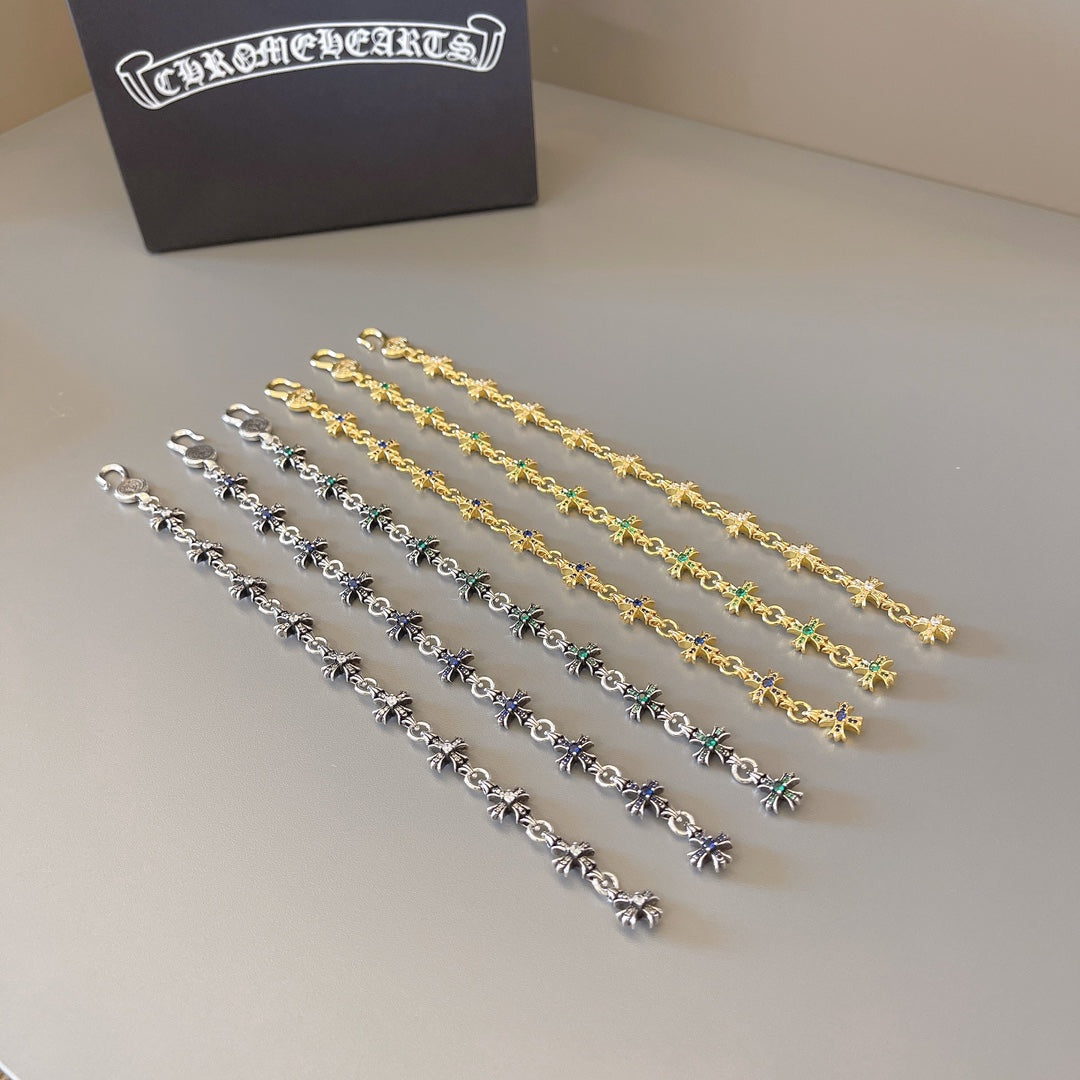Charm bracelet set in silver, gold, and blue-green with star link pendants