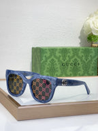 Gucci sunglasses with blue frame, GG pattern, dark lenses, and gold logo emblem