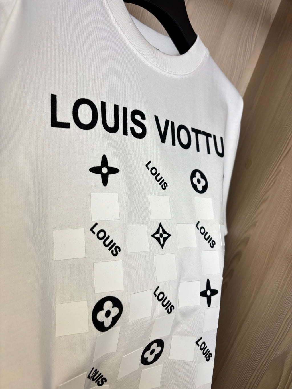 White crewneck T-shirt close-up of “LOUIS VIOTTVN” icon graphic