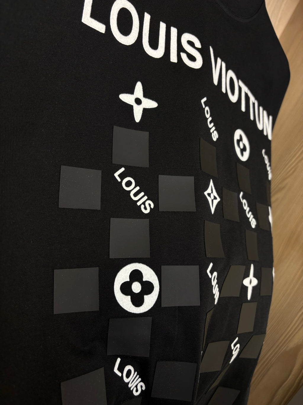 Black crewneck T-shirt close-up of “LOUIS” icon graphic and squares