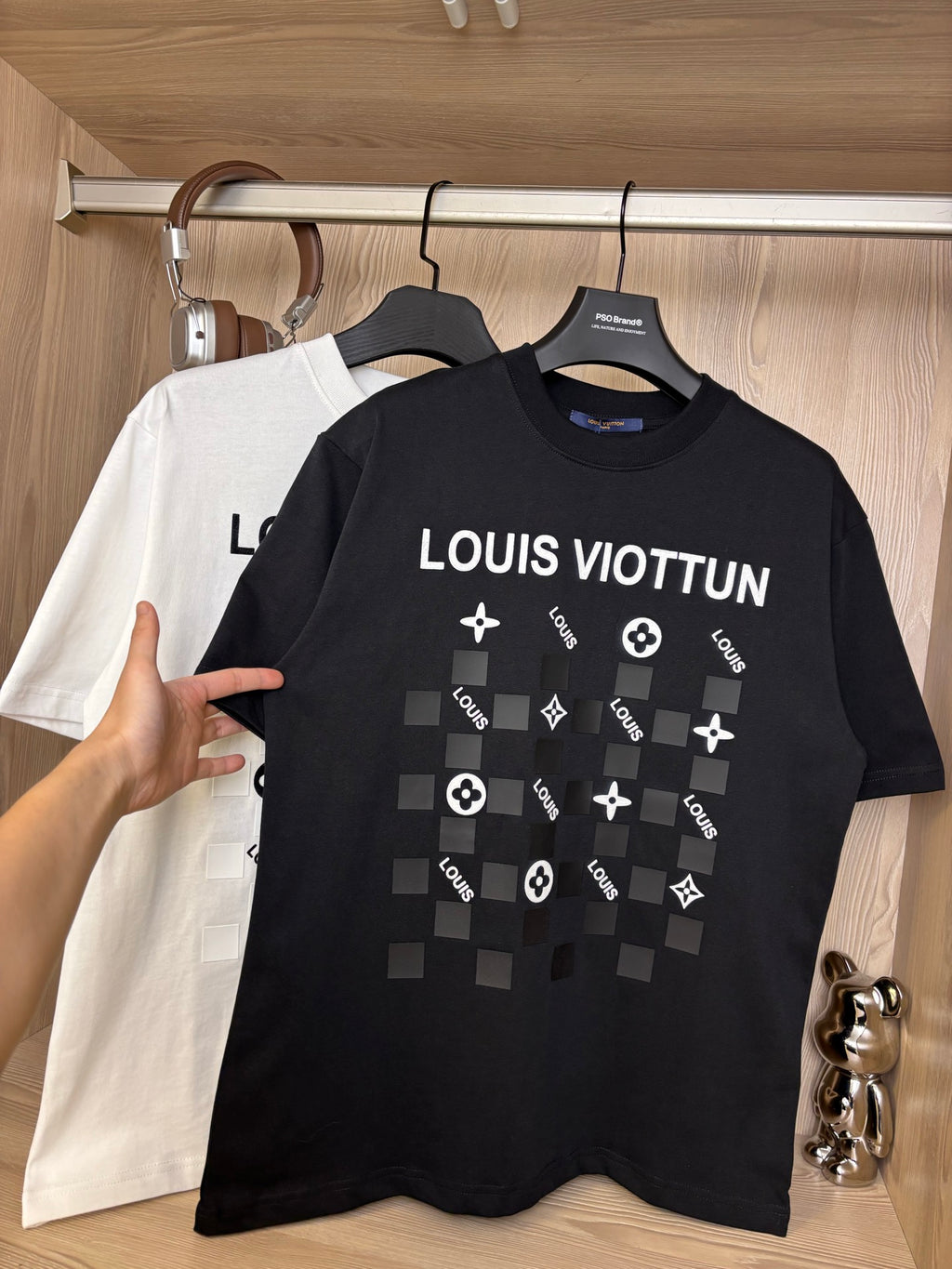 Black crewneck T-shirt with “LOUIS VIOTTVN” chest graphic, white shirt behind