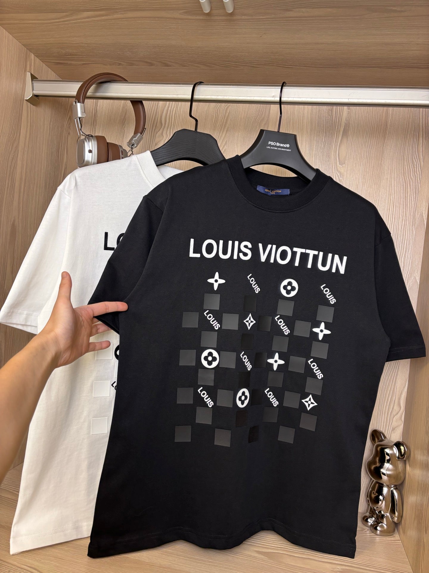 Black crewneck T-shirt with “LOUIS VIOTTVN” chest graphic, white shirt behind