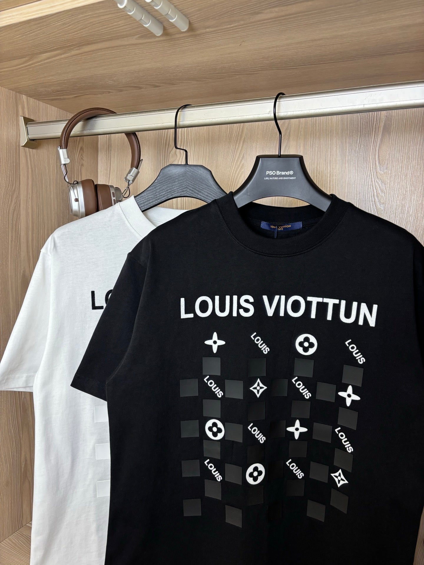 Black crewneck T-shirt with “LOUIS VIOTTVN” chest graphic, white shirt behind