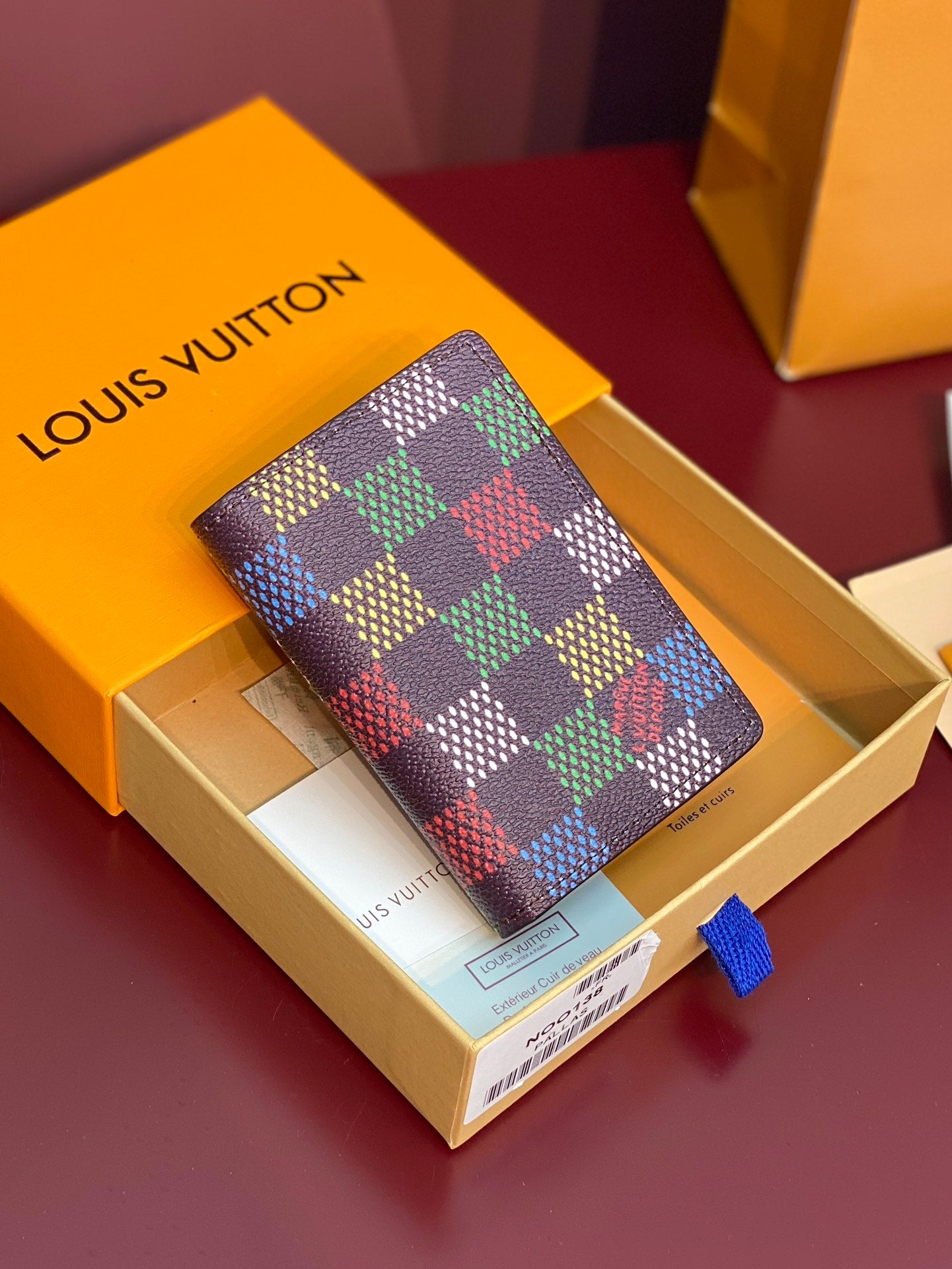 Louis Vuitton checkered small wallet with multicolor pattern and brown leather trim