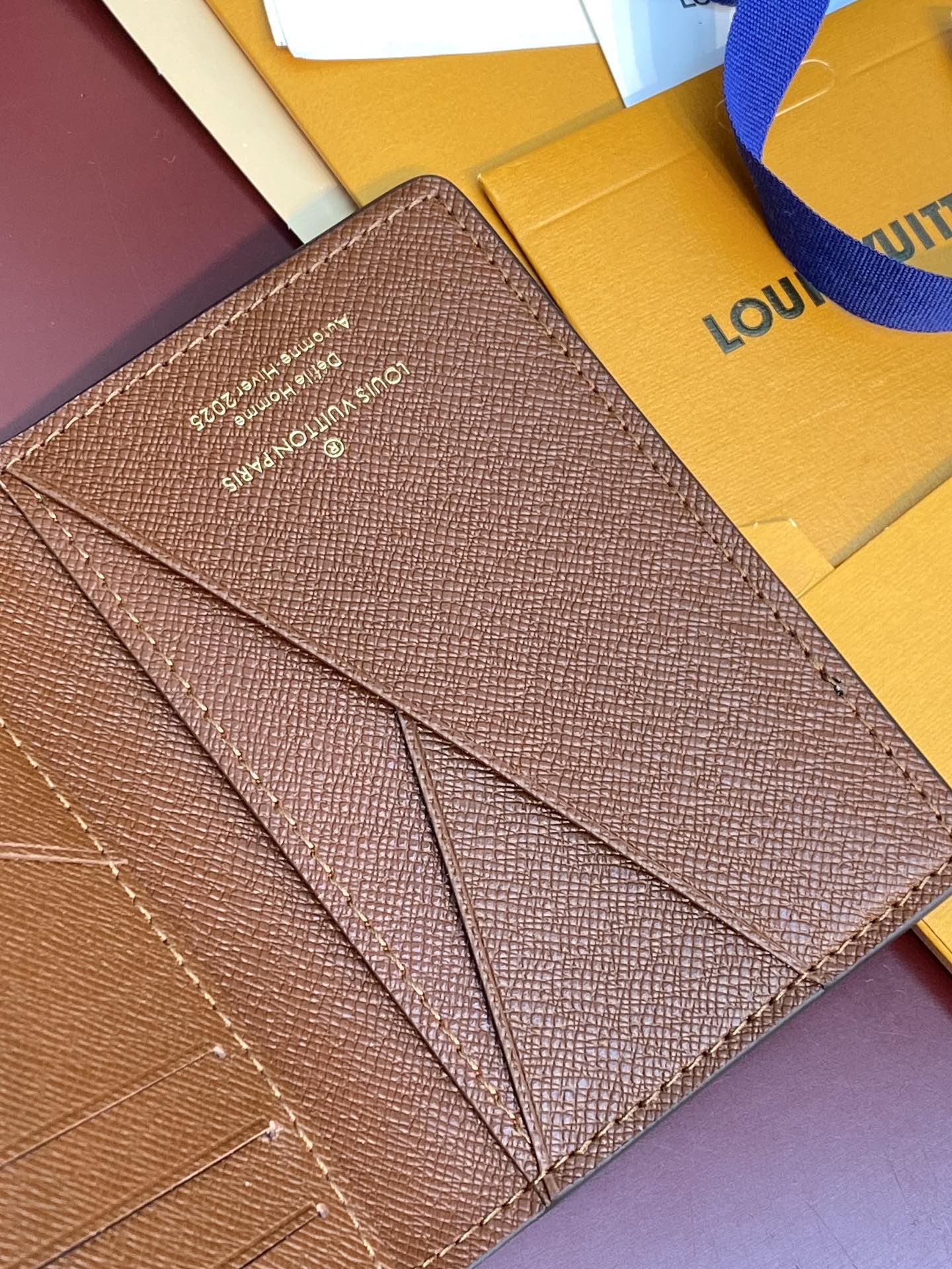 Louis Vuitton textured small wallet with long stitched panel and signature text