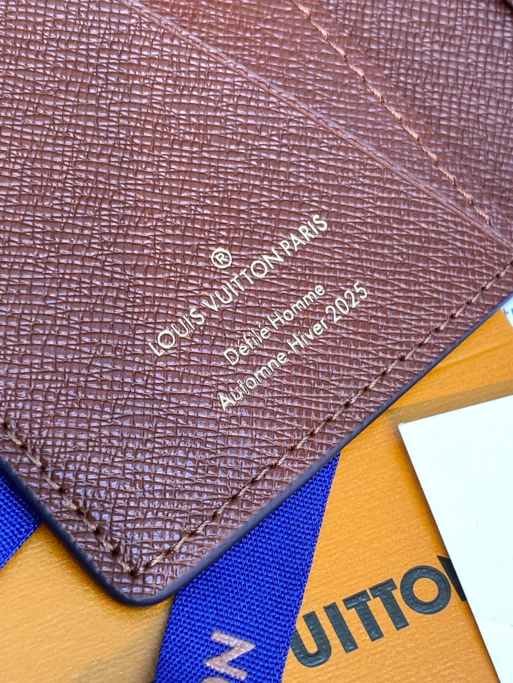 Louis Vuitton textured leather wallet panel with embossed logo and decorative stitching