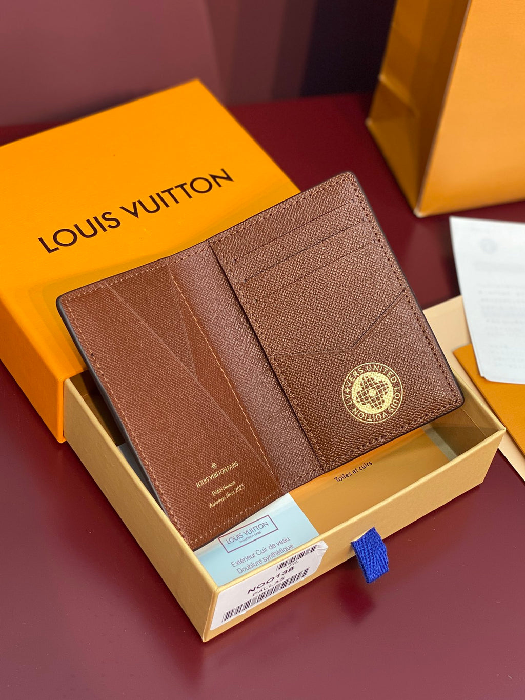 Louis Vuitton textured small wallet with flap detail and round logo emblem