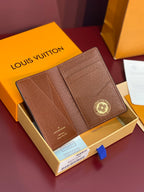 Louis Vuitton textured small wallet with flap detail and round logo emblem