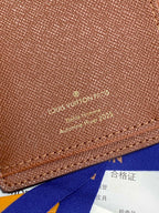 Louis Vuitton brown textured small bag close-up with gold logo imprint