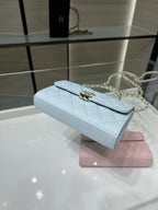 Chanel light blue quilted flap bag on display with gold chain strap