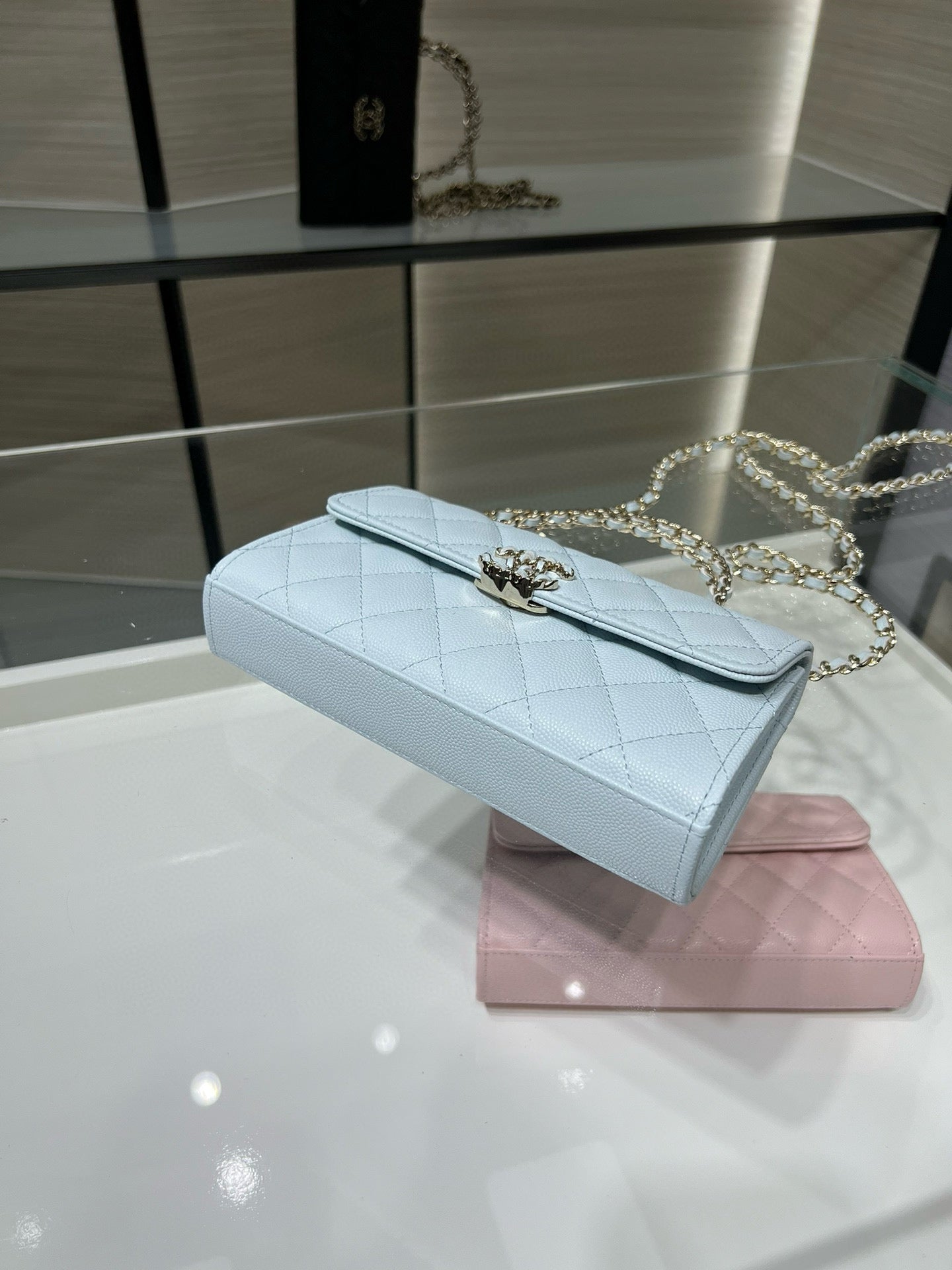 Chanel light blue quilted flap bag on display with gold chain strap