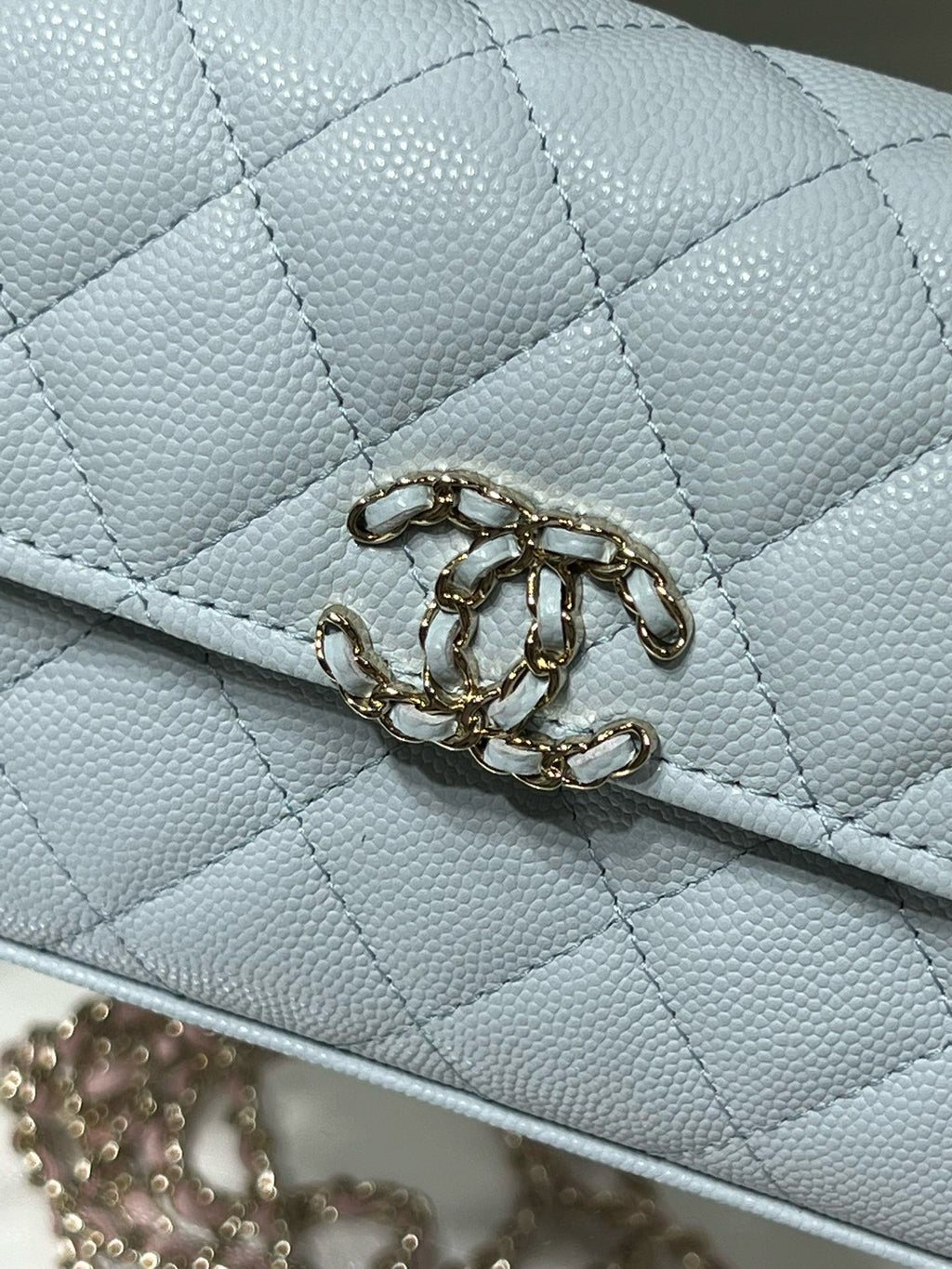 Chanel light blue quilted flap bag close-up of gold chain clasp