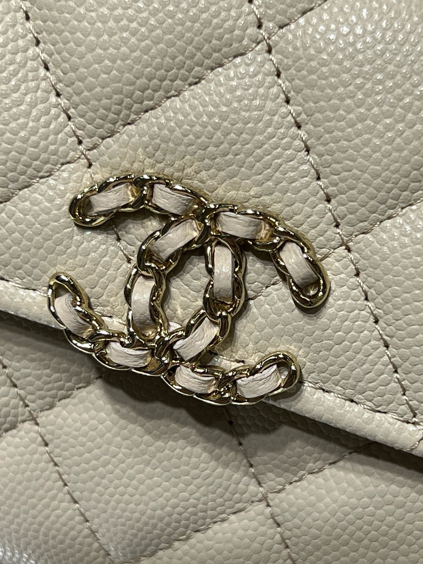 Chanel cream bag front clasp and decorative gold chain hardware detail