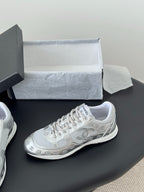 Chanel unisex white sneaker with lace-up front and side logo, on display