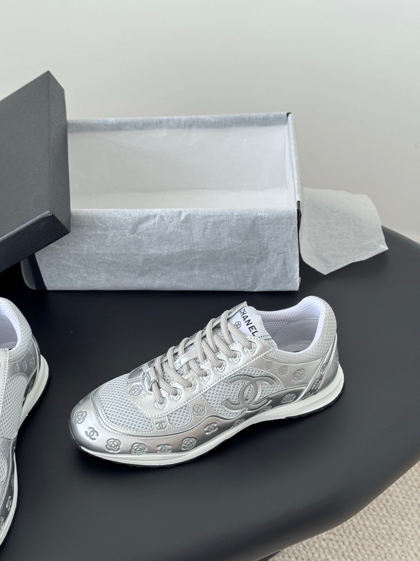 White Chanel unisex sneaker with lace-up front and patterned outsole