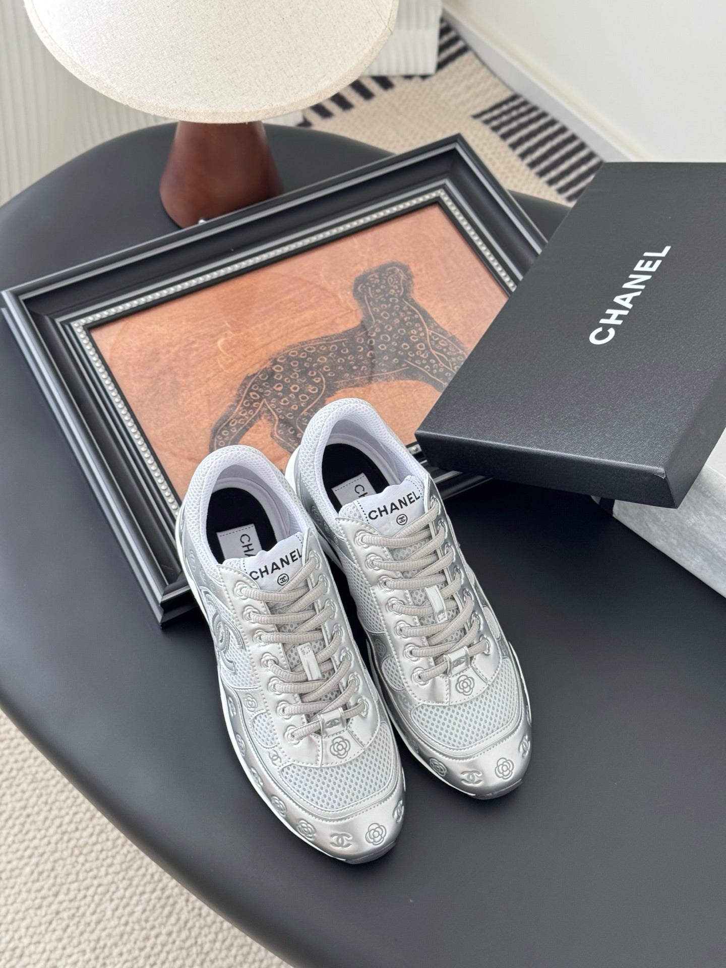 Chanel unisex white lace-up sneakers with side logo, resting with gift box