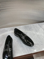 Black patent loafers with silver buckle strap and PRADA logo on upper