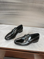 Black patent loafers with double strap silver buckle, pair on display