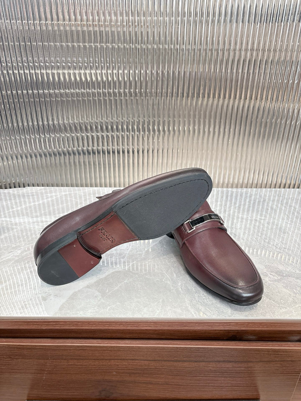 Prada unisex leather loafers, sole view with buckle strap, dark burgundy
