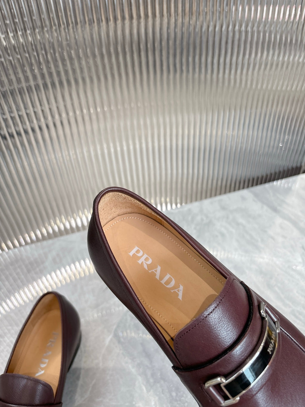 Prada unisex loafers, close-up of insole PRADA logo, burgundy buckle
