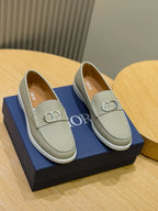 Light beige loafer pair with silver-tone D buckle and stitched trim