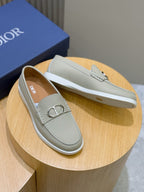 Light beige loafers on display with silver-tone D buckle