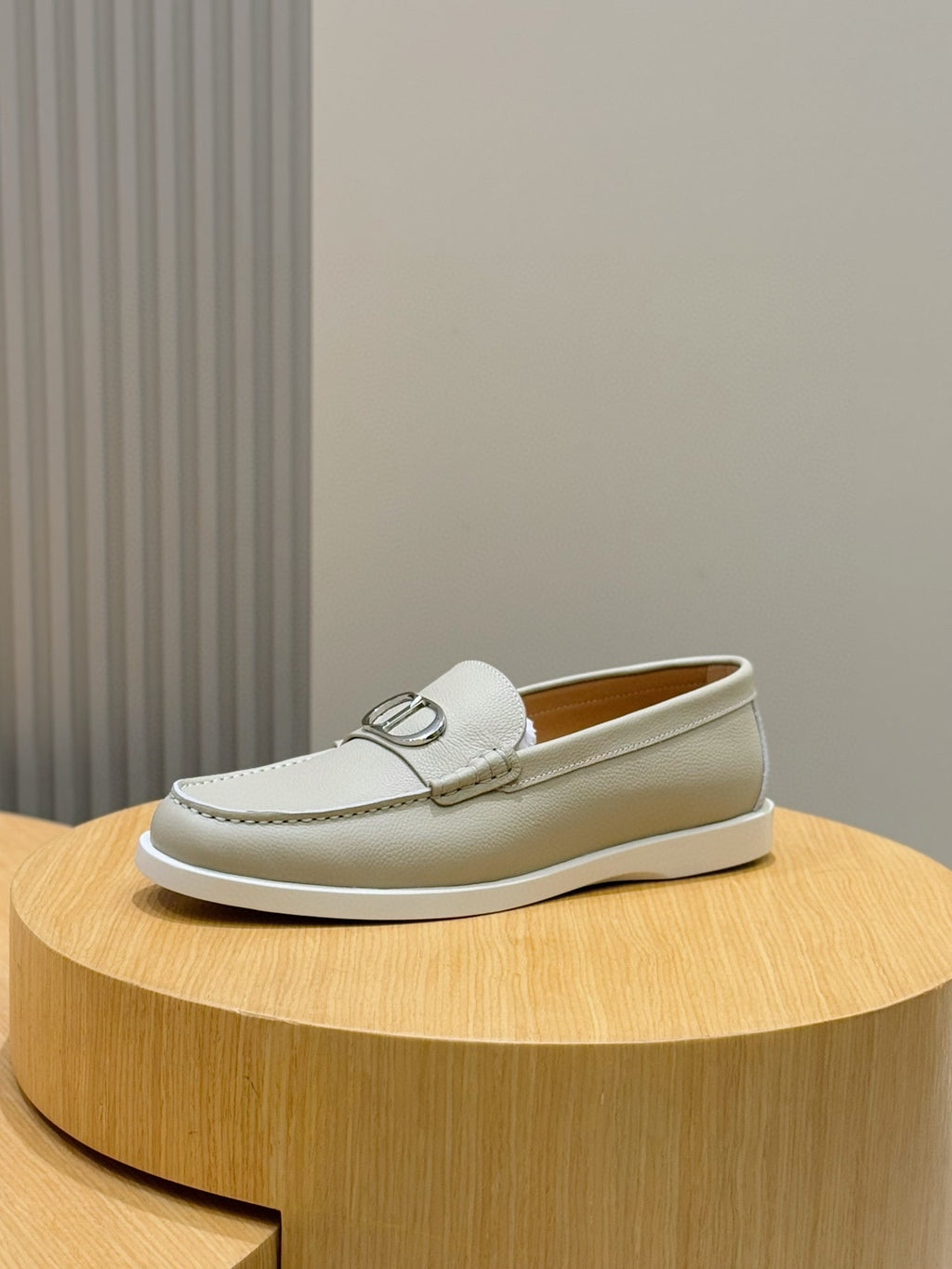 Light beige leather loafer with silver-tone buckle and low flat sole