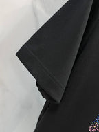 Black T-shirt sleeve and hem detail on a hanger, no graphic visible on this area