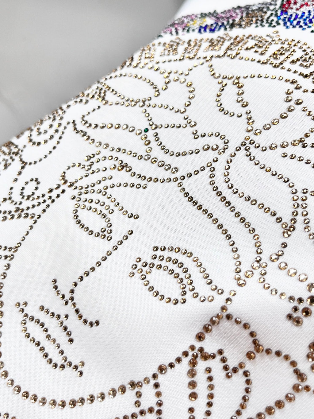 Versace white T-shirt close-up of Medusa rhinestone swirl pattern on chest
