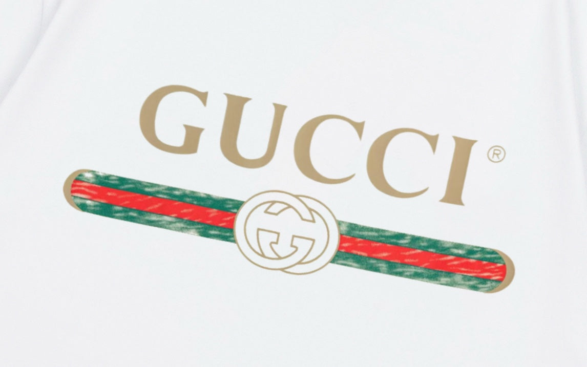 Close-up of GUCCI logo and red-green stripe graphic on white T-shirt