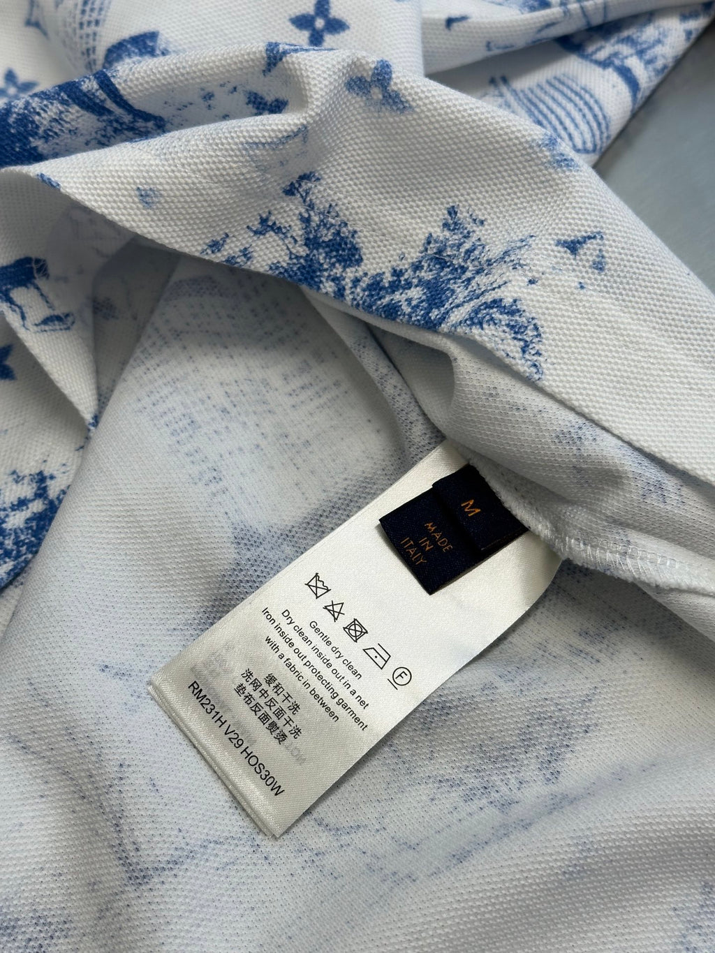 Inside collar and care label on off-white T-shirt with blue printed motif