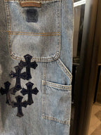 Light-wash denim pocket panel with embroidered black cross patch