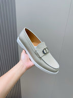 Light beige loafer in hand with silver-tone D buckle and stitched edge