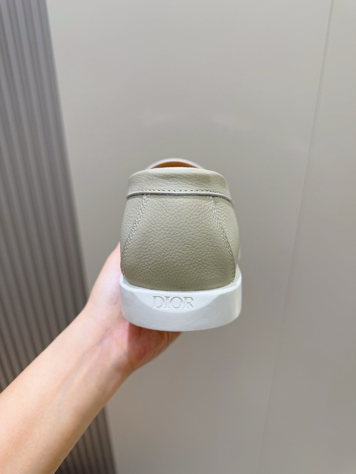 Back view of light beige leather loafer with cushioned heel