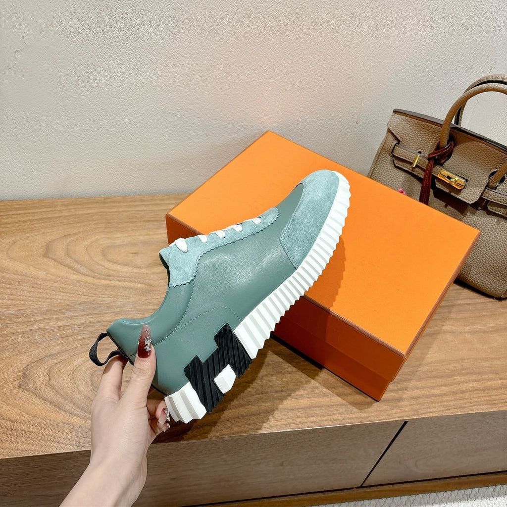 Hermes mint unisex sneaker outsole in hand: treaded white sole with black traction pads.