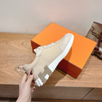 White slip-on sneakers with chunky ribbed sole and side cutout panel