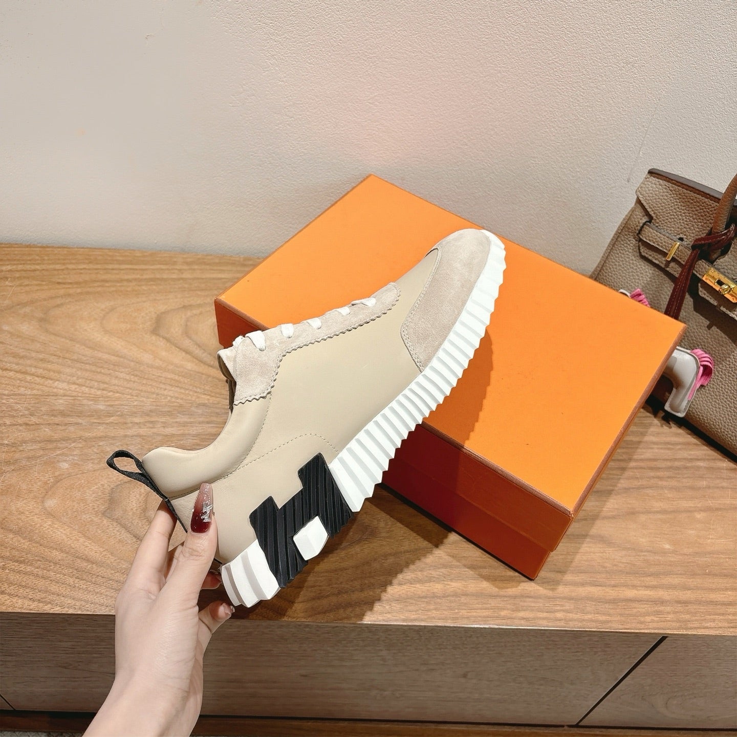 Cream unisex sneaker with white laces and ribbed sole; angled side view.