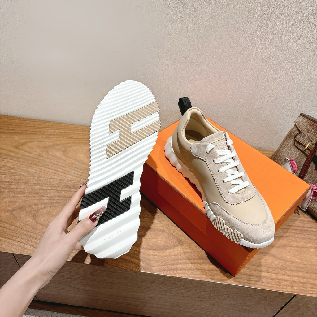 Unisex sneakers on box showing treaded sole with black heel and white sidewall.