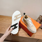 Unisex sneakers on box showing treaded sole with black heel and white sidewall.