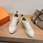 Cream unisex sneakers with white laces and ridged rubber outsole; side view pair.