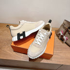 Cream unisex sneakers with white laces and black rubber accents on the sole.