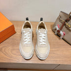 Cream unisex sneakers with white laces, cushioned sole, and black heel tabs.