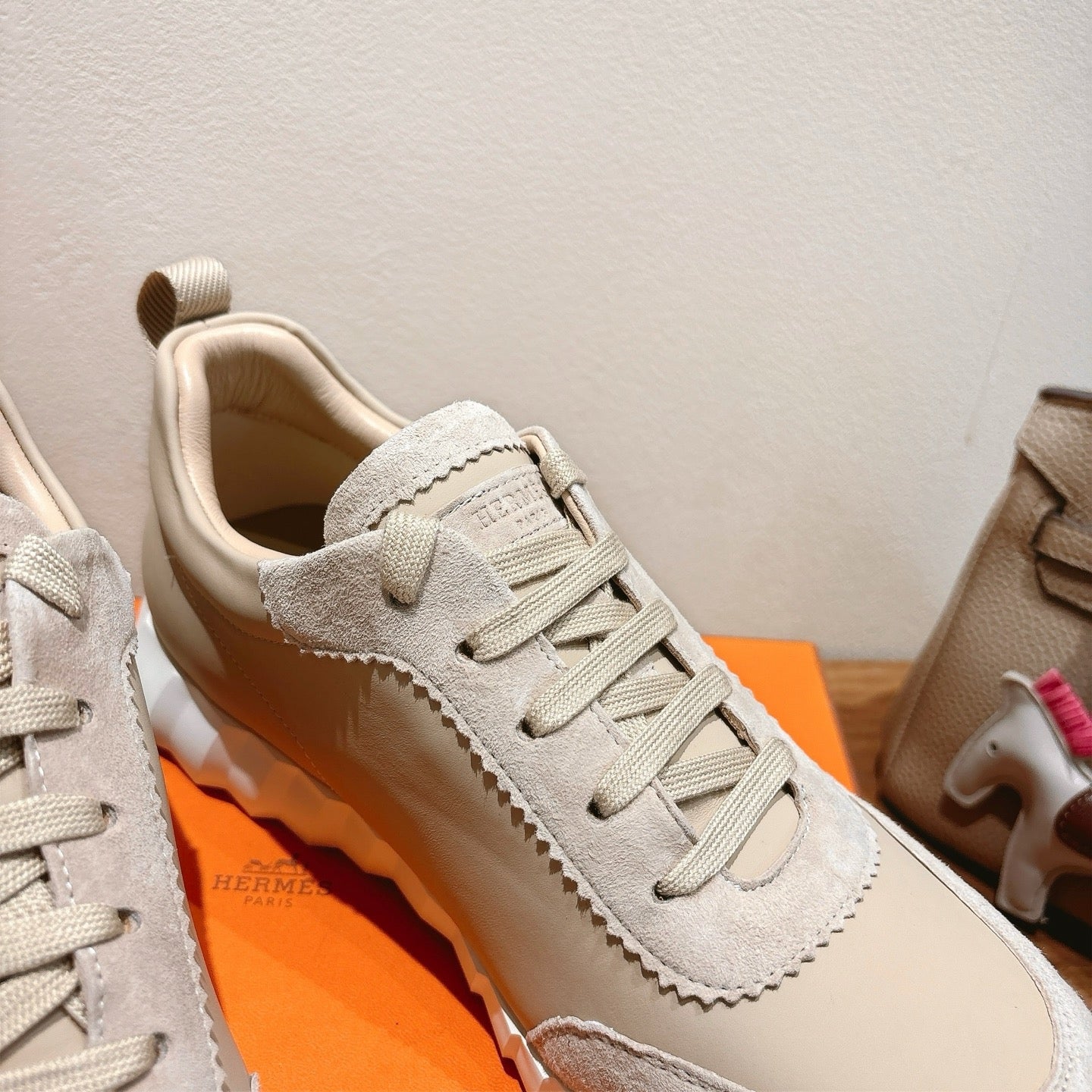 White sneaker quarter panel with lace-up eyelets and textured stitching detail