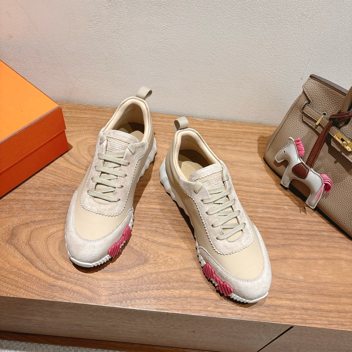 Pair of white lace-up sneakers with pink-and-brown accents at the sides