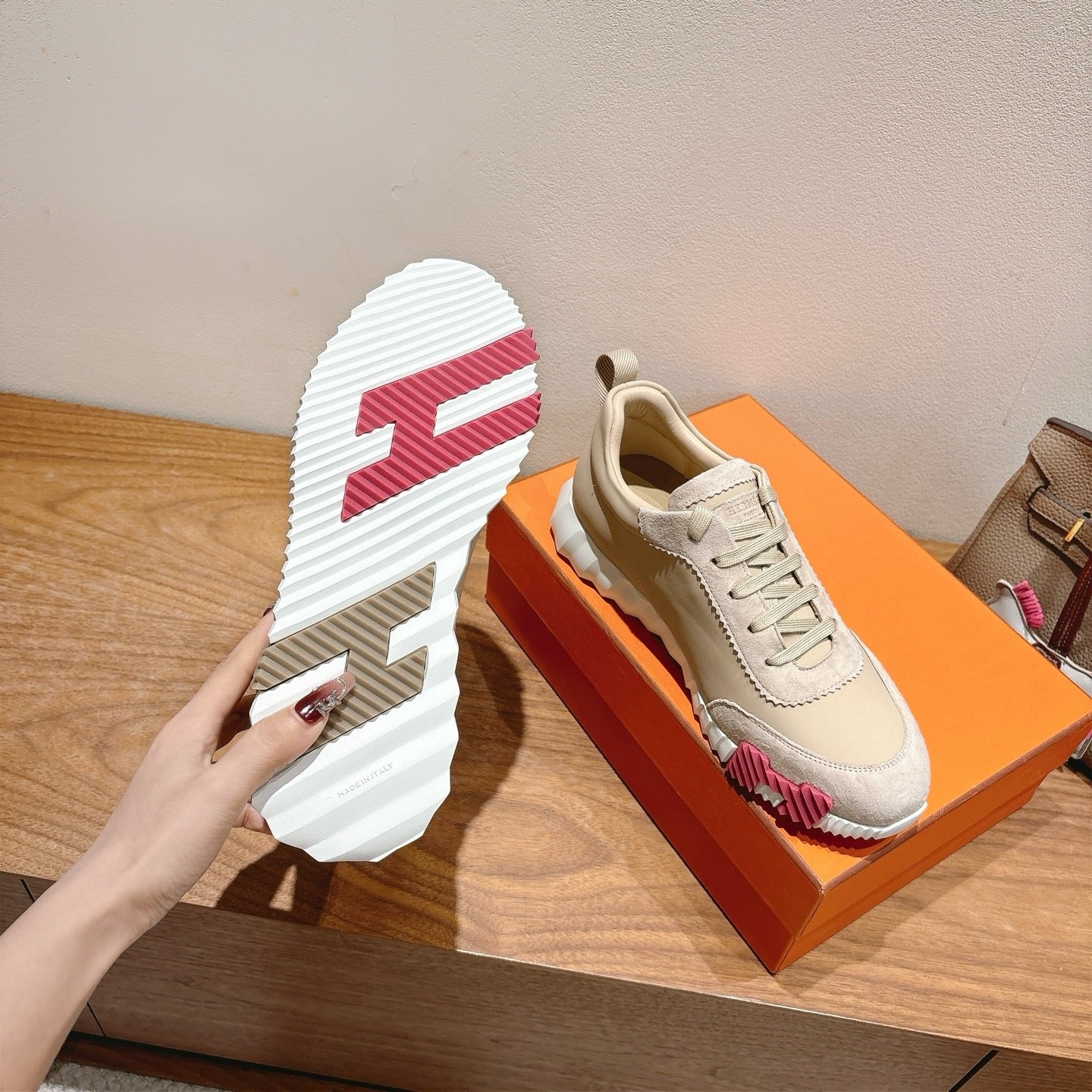 White lace-up sneakers with striped rubber outsole and pink accent at side